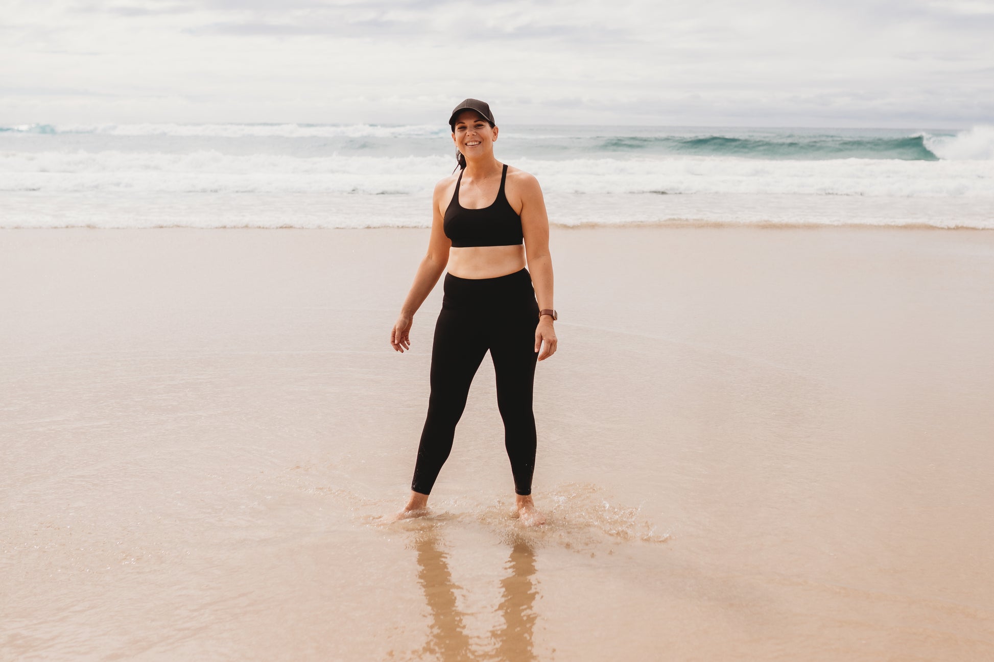 Women at the beach wearing the marlz and me Classic Black Cross Sports Bra and Classic Black Full Length Tights at the beach on a beautiful sunny day.