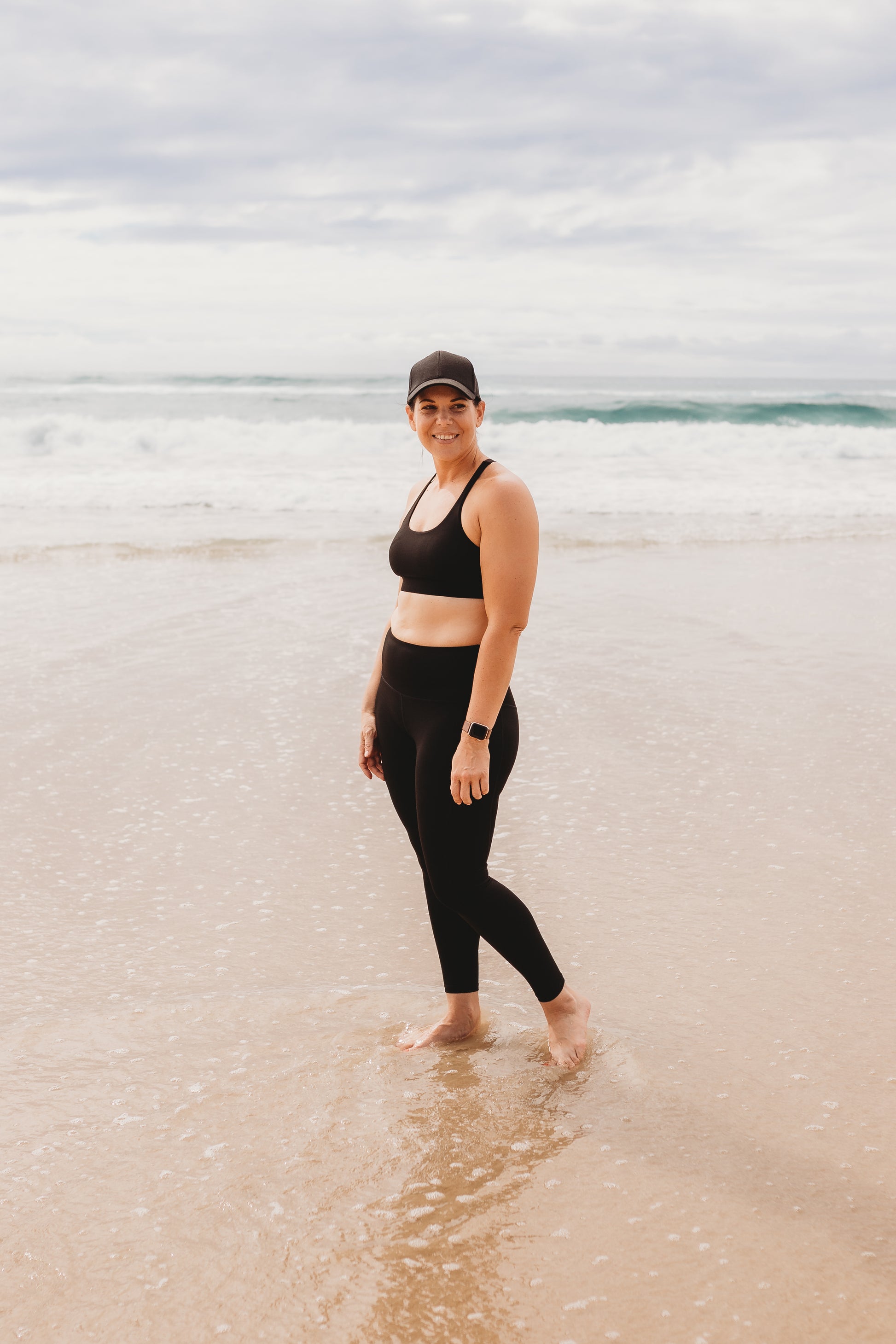 Women at the beach wearing the marlz and me Classic Black Cross Sports Bra and Classic Black Full Length Tights at the beach on a beautiful sunny day.
